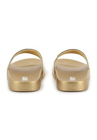 Gouden slidesandalen met een gestructureerde voetbed, open achterkant en twee brede bandjes, met een glanzende afwerking en minimalistisch ontwerp.