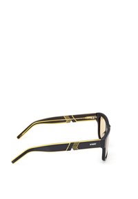 Occhiali da sole neri con finitura opaca, caratterizzati da accenti gialli e aste affusolate. Lenti quadrate con un design elegante e un logo sulla tempia.