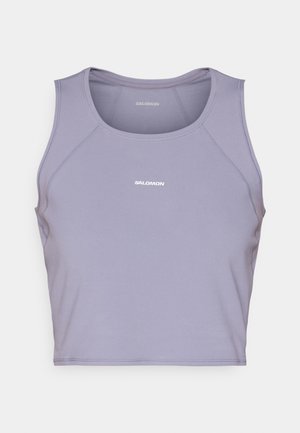 Violeta sporta krūšturis, izgatavots no mīkstas, elastīgas auduma. Tam ir noapaļots kakla izgriezums un bez piedurknēm izstrādājums ar smalkiem šuvju elementiem.