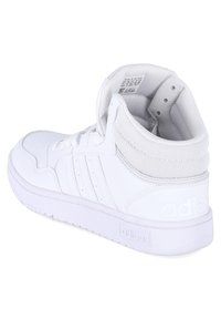 Baskets montantes blanches avec un dessus en cuir lisse et en maille, un embout perforé, un design à trois bandes et un col rembourré.