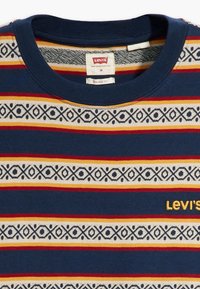 Navyblauw T-shirt met meerkleurige horizontale strepen en geometrische patronen, voorzien van een ronde halslijn en een geel geborduurd "Levi's"-logo.