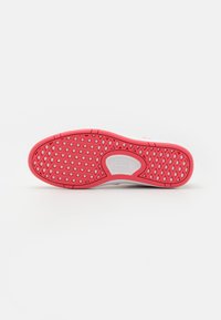 Vans cipőtalp fehér és élénk rózsaszín gumiból, struktúrált tapadási mintával és logókialakítással, hatszög és gyémánt mintázattal.