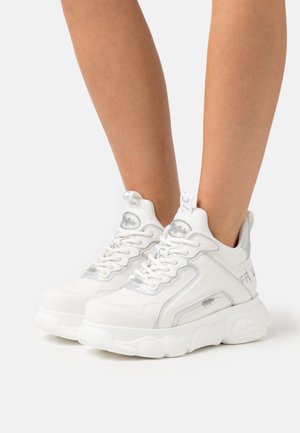 Sneakers bianchi in pelle texturizzata, con dettagli argentati e suola spessa. Presentano una chiusura con lacci e dettagli con logo sul lato.