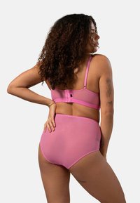 Roze lingerieset met een doorschijnende, lichte beha en een hoge slip. Beide stukken hebben verstelbare bandjes en een zachte textuur.