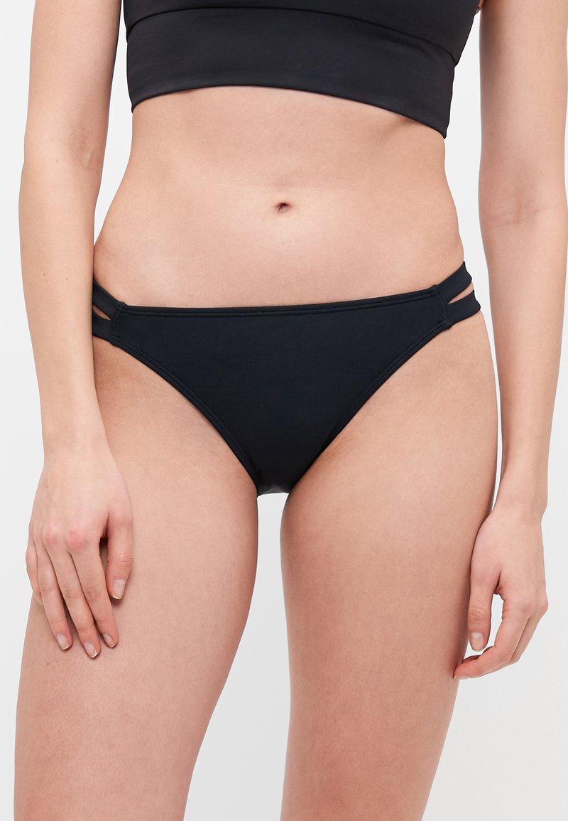 Black bikini bottoms featuring a low-rise cut, smooth fabric, and two side straps for detail. The design is minimalist and fitted.