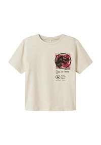 Camiseta de algodón color crema con mangas cortas. Presenta un gráfico de dinosaurio negro y el texto "Caution" en rojo en la parte delantera, con texto adicional debajo.