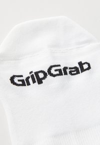 Calzino bianco con una texture a coste, con il logo nero "GripGrab" lavorato nella zona della caviglia. Design semplice e sportivo.