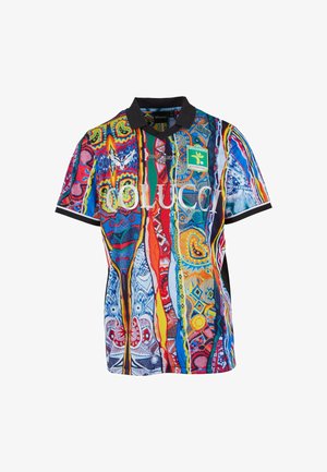 Buntes kurzärmliges Poloshirt mit abstrakten Mustern, schwarzem Kragen, schwarzen Ärmelenden und Logos, darunter "COLUCCI" und ein grüner Patch des "Fussballclub Kitzbühel".