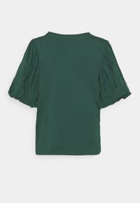 Maglietta verde scuro a maniche corte con strisce arricciate che scorrono verticalmente lungo le maniche voluminose, retro semplice e scollatura rotonda.