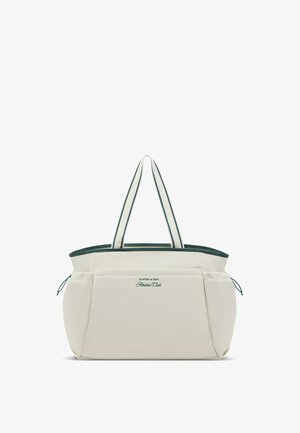 Beige und dunkelgrüne Tragetasche mit zwei gestreiften Griffen und einer Vordertasche, beschriftet mit "Kapten & Son Athletic Club."