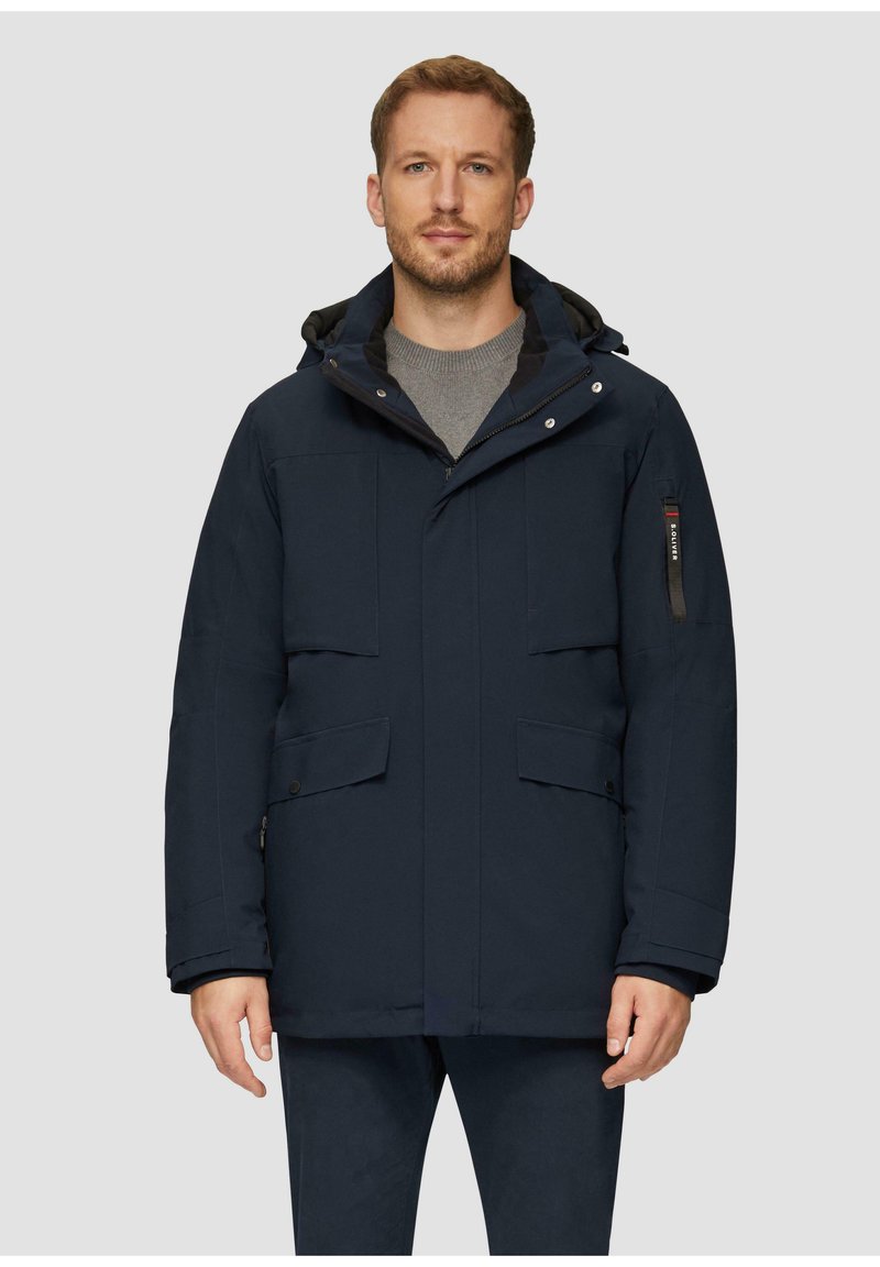 Parka bleu marine avec capuche, dotée de plusieurs poches, d'une fermeture éclair à l'avant et de fermetures à pression, fabriquée dans un matériau doux et texturé.