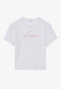 Hvid bomulds T-shirt med korte ærmer. Har lyserød broderet tekst "No regrets" over en lille lyserød sløjfe. Klassisk rund halsudskæring.
