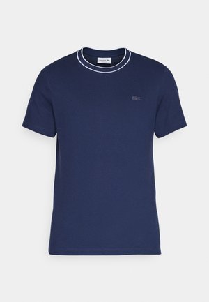 Camiseta de algodão azul-escuro com gola redonda e detalhes brancos. Apresenta mangas curtas e um pequeno logotipo bordado no peito.