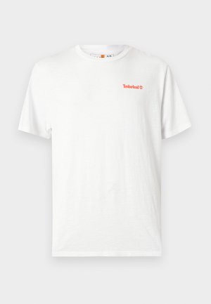 Valge lühikeste varrukatega T-särk, millel on vasakul rinnal väike oranž Timberlandi logo, esitatud ühevärvse heleda tausta peal.