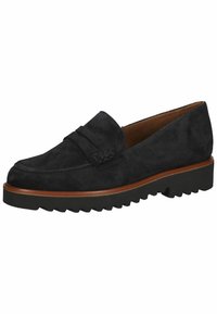 Mocassin en daim noir avec un profil bas, un dessus texturé, et une semelle en caoutchouc marron contrastante avec un bord cranté.