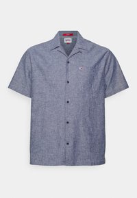 Camicia a maniche corte con bottoni in tessuto intrecciato blu scuro. Presenta un colletto, una tasca sul petto e una piccola etichetta con logo sul lato sinistro.