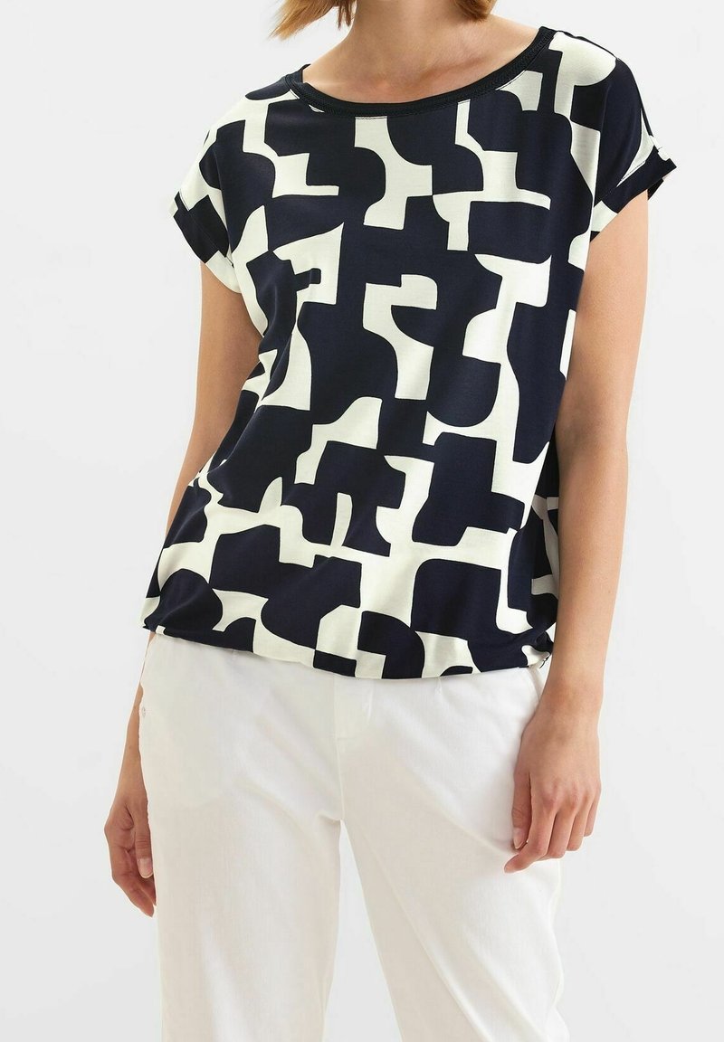 Kortärmad topp i marinblått och krämfärgat med ett abstrakt mönster, rund halsringning och lös passform. Tillverkad av mjukt, lätt tyg.