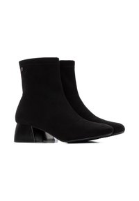 Botas de ante negras hasta el tobillo con punta afilada y tacón de bloque que presenta un detalle de acento transparente. Textura suave con bordes cosidos.