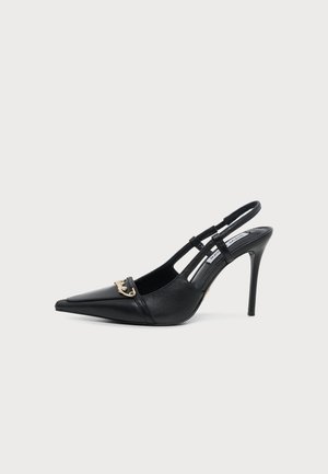 Black leather slingback high heel shoe with pointed toe and gold chain detail on front against plain background.