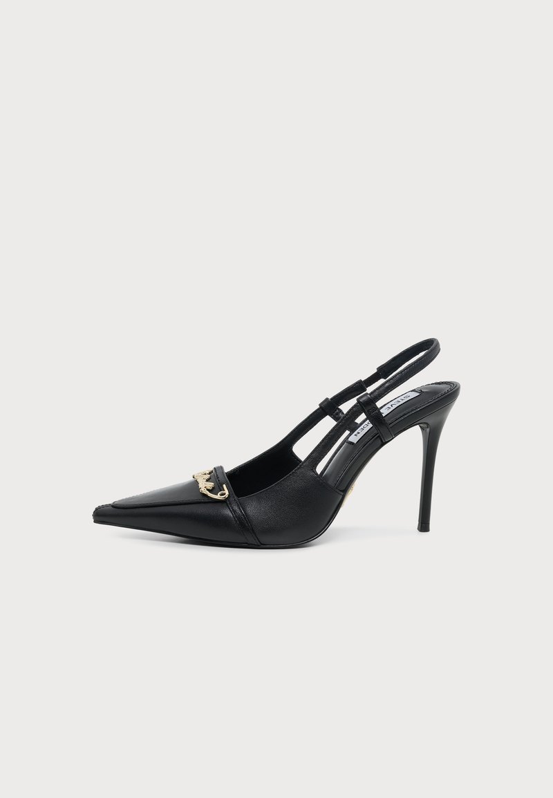Chaussure à talon haut slingback en cuir noir avec bout pointu et détail chaîne dorée sur l’avant sur fond uni.