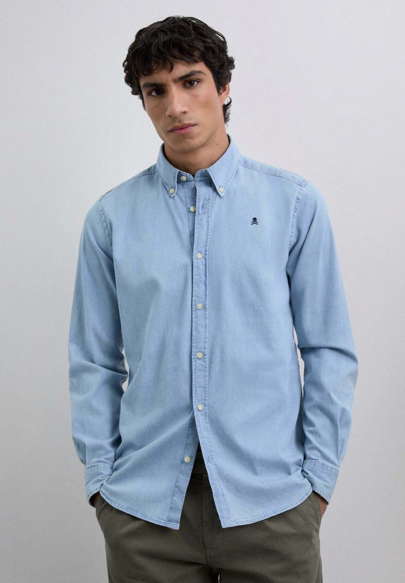 Lichtblauwe overhemd met kraag, lange mouwen en een klein geborduurd logo op de borst. Gemaakt van katoen, met een gladde textuur.