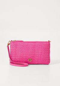 Vaaleanpunainen kudottu clutch-laukku, jossa on kultainen mehiläislogo ja irrotettava rannekahva, valkoisella taustalla.