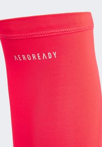 Rote Sportleggings aus einem glatten, dehnbaren Stoff mit figurnahem Schnitt. Mit einem weißen "AEROREADY"-Logo in der Nähe des Bundes.