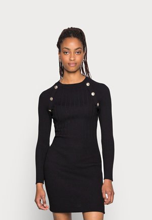 Black ribbed knit dress with long sleeves, featuring silver button accents on the shoulders and a form-fitting silhouette.