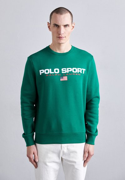 Sweatshirt vert avec col rond côtelé, mettant en avant "POLO SPORT" et "RALPH LAUREN" en texte blanc et rouge, ainsi qu'un petit détail du drapeau américain.