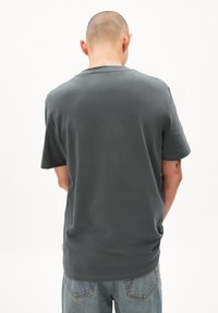 Grijze katoenen T-shirt met korte mouwen en een ronde hals, met een gladde textuur en een relaxte pasvorm, gezien van de achterkant.