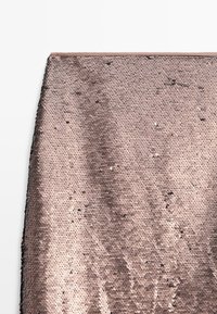 Roségoldene Paillettenstoffe mit kreisförmigen, überlappenden Pailletten, die eine strukturierte, reflektierende Oberfläche erzeugen. Glatte Kanten mit einem sanften Glanz.