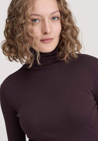 Diep paarse coltrui met een slim-fit ontwerp en een zachte textuur. Beschikt over een hoge nek en lange mouwen, geschikt voor het lagen van outfits.