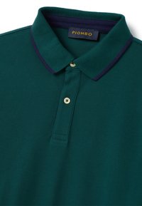 Polohemd in dunkelgrün mit strukturiertem Stoff. Verfügt über einen marineblauen Kragen, eine drei-knopfige Knopfleiste und ein "PIOMBO" Markenetikett.