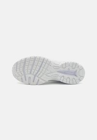 Suola di scarpa sportiva bianca realizzata in gomma testurizzata con modelli di battistrada prominenti per una migliore trazione. Include un logo del marchio ben visibile sul lato.