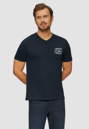 Granatowa koszulka typu v-neck wykonana z miękkiej bawełny, z krótkimi rękawami i małym białym logo na lewej piersi. Gładka faktura.