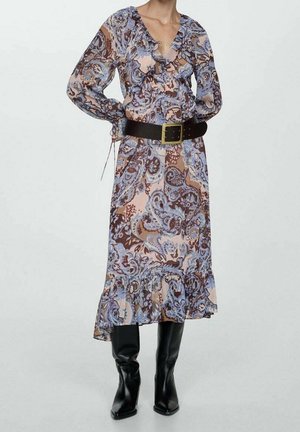 Robe longue et fluide avec un motif paisley dans des tons marron et bleu, avec un décolleté volé et des manches longues, cintrée à la taille par une ceinture noire.