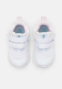 Zapatillas deportivas blancas con parte superior de malla, interior acolchado en rosa, dos correas de Velcro y suela de goma texturizada. Detalles azules en la plantilla.