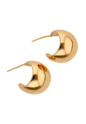 Pár fényes, félhold alakú arany karika fülbevaló, fülbevaló csappal, átszúrt fülre, fehér háttéren.