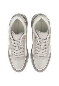 Un paio di sneaker bianche e grigie chiare di Tommy Hilfiger con lacci, dettagli in suede e logo sulla linguetta e sulla soletta, viste dall'alto.