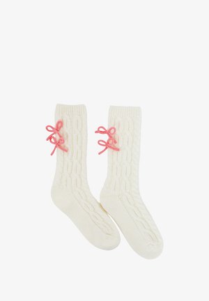 Strickcreme-Socken mit einem Zopfmuster. Jede Socke hat rosa dekorative Schleifen an der Seite, die ein texturiertes Detail hinzufügen.