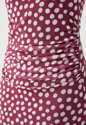 Tessuto viola con pois bianchi, caratterizzato da dettagli arricciati lungo i lati, creando un aspetto testurizzato.