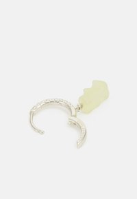 Pendiente de aro de plata con un diseño texturizado, adornado con un acento de resina de forma irregular en un verde claro que cuelga de él.