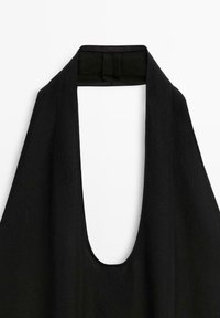 Haut halter noir avec un décolleté en V profond et un tissu texturé. Le décolleté présente une finition soignée et une fermeture à crochet et œillet.