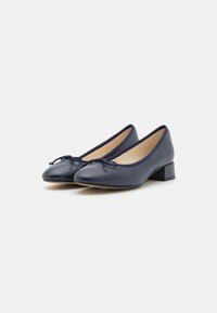 Décolleté in pelle blu navy con tacco basso a blocco, punta arrotondata e fiocco decorativo sull'area della punta. Texture liscia con finitura opaca.