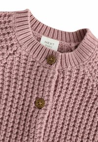 Cardigan per neonati in rosa lavorato a maglia con un motivo testurizzato, con bordi a costine e due bottoni in legno. L'etichetta recita "NEXT baby."