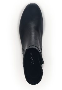 Sorte lær ankelsko med en glatt tekstur, avrundet tå og glidelås på siden. Har et slankt, minimalistisk design uten dekorasjoner.