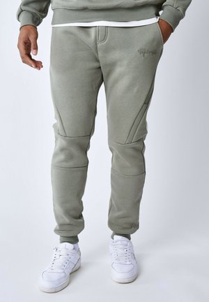 Pantalons de survêtement vert olive avec des poignets côtelés et des détails de panneau latéral. Fabriqués à partir d'un tissu doux, comportant un logo brodé sur la cuisse.