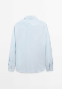 Camicia azzurro chiaro a maniche lunghe con colletto button-down, orlo dritto e polsini con bottoni. Texture liscia, design con un unico yoke posteriore.