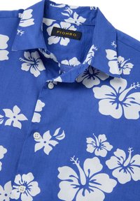 Camisa de manga corta azul de algodón, con un patrón floral de hibiscos blancos, botones y un cuello clásico. Etiqueta: PIOMBO.