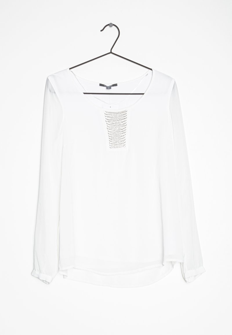 Hvid langærmet bluse med en rund halsudskæring og en dekorativ, struktureret panel foran. Stoffet ser glat og letvægtigt ud.